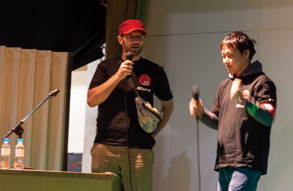 写真1　 Node.jsスタッフのMartin Heideggerさん（左）とJSConf JPで司会進行中の古川さん（右）