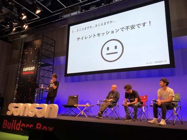 サイレントセッション。壇上に上がっているスピーカが使用するマイクは、会場内に音を出力せず、各セッションの参加者のイヤホンごとに配信される仕掛けとなっていた